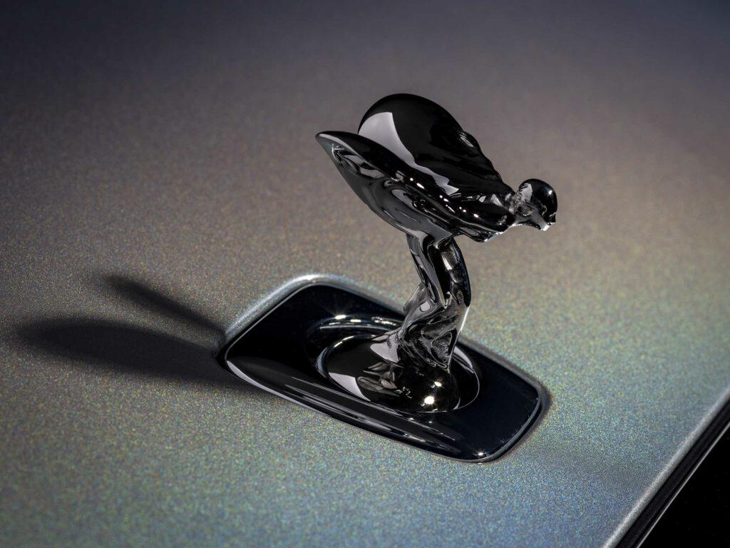 Detailní záběr na ikonickou sošku Spirit of Ecstasy na kapotě vozu, která se vyjímá na speciálním perleťovém laku.